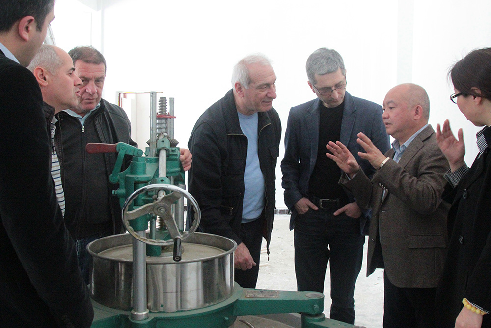 滇红集团董事长王天权向格鲁吉亚代表团介绍揉茶设备